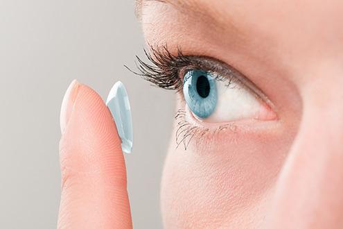 a woman applying contact lenses